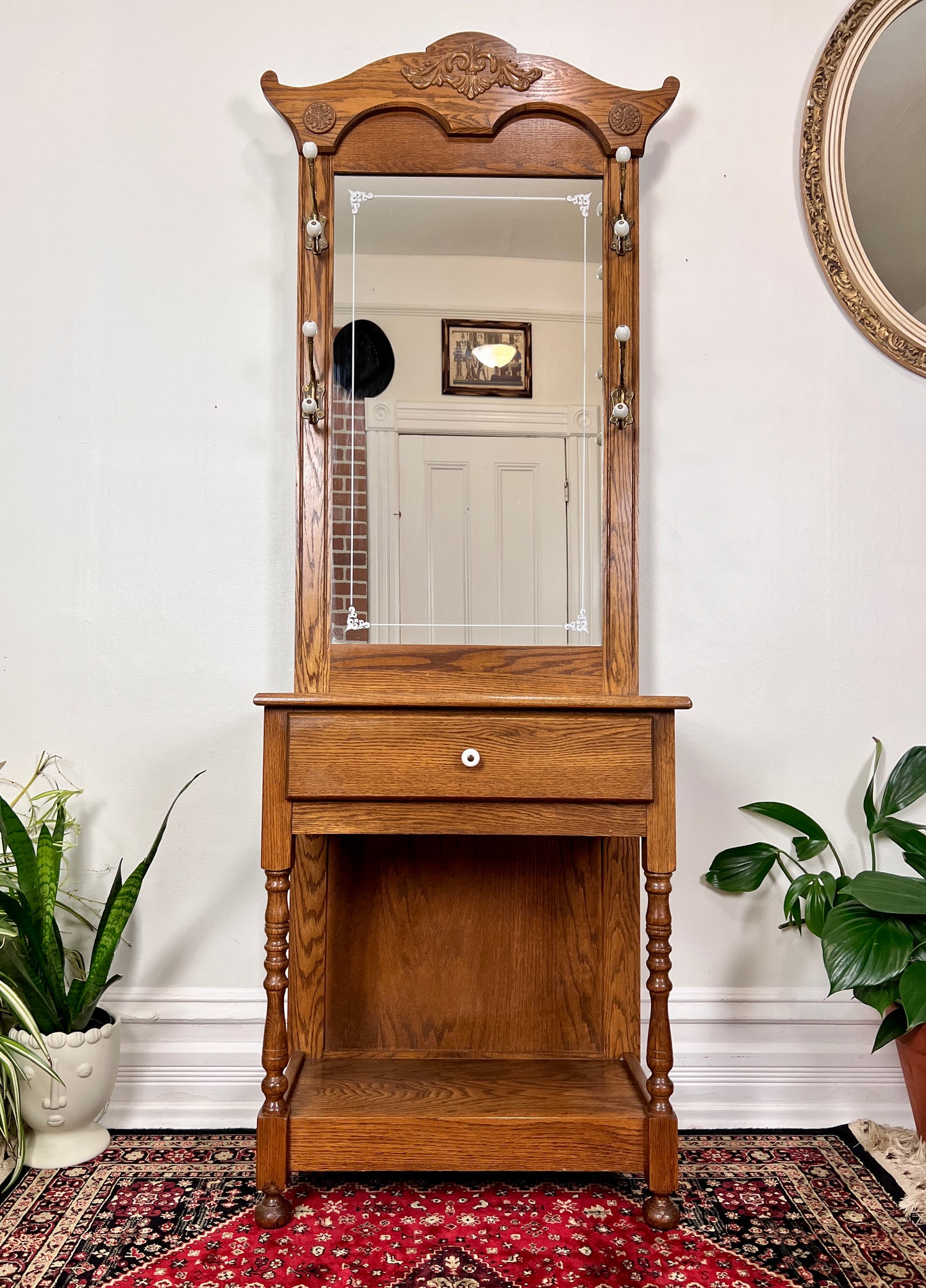 This is a vintage oak hall tree table with mirror, coat hooks & drawer.