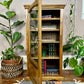This is a vintage english oak record cabinet with 5 shelves and a glass door.