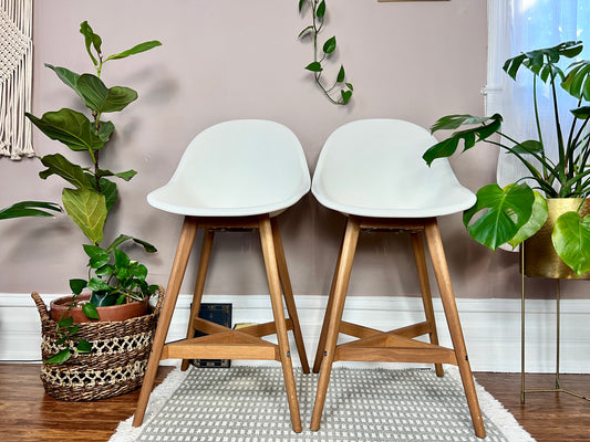 These are retro white egg chair style stools in white plastic and natural wood legs.