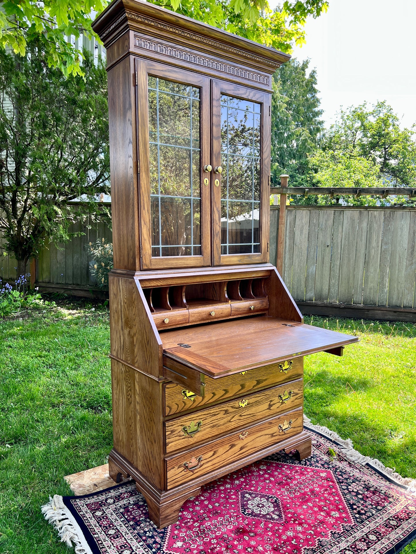 This is an amazing solid tanned oak secretary desk with glass top cabinet.